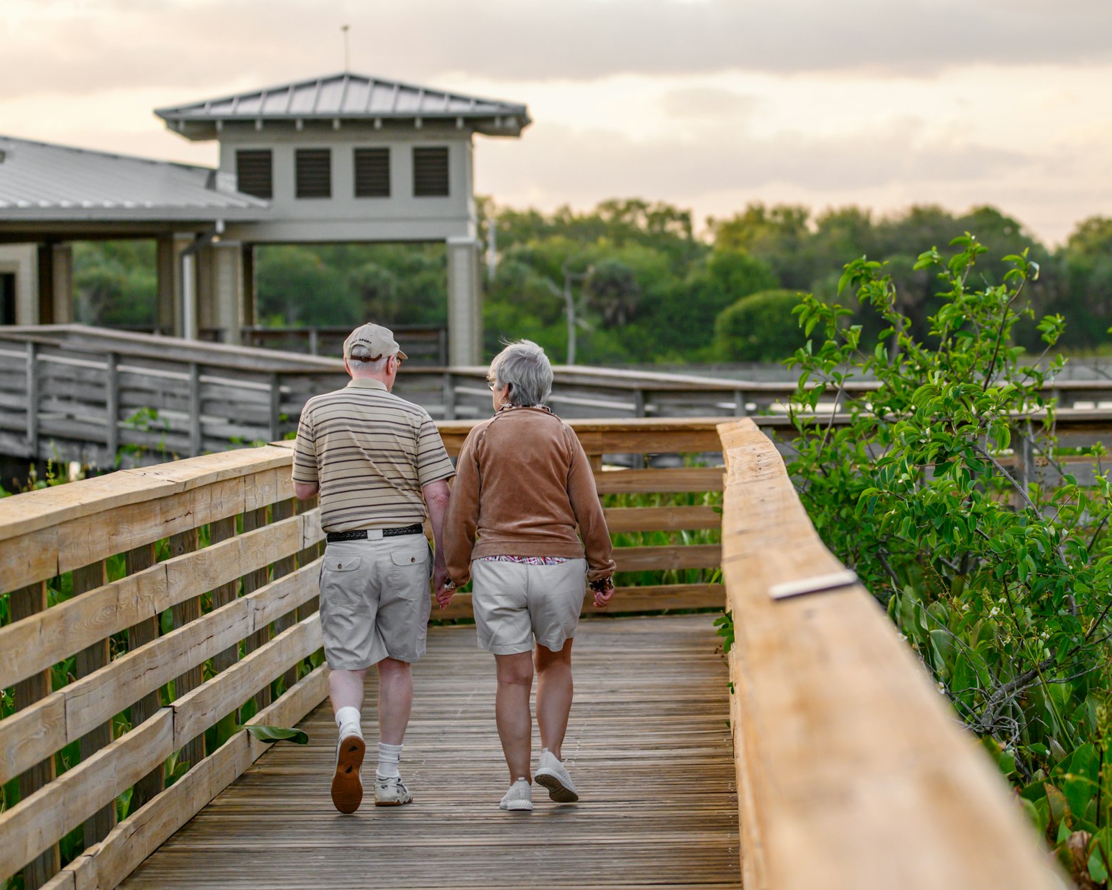 Older couple walking together on a wooden boardwalk
