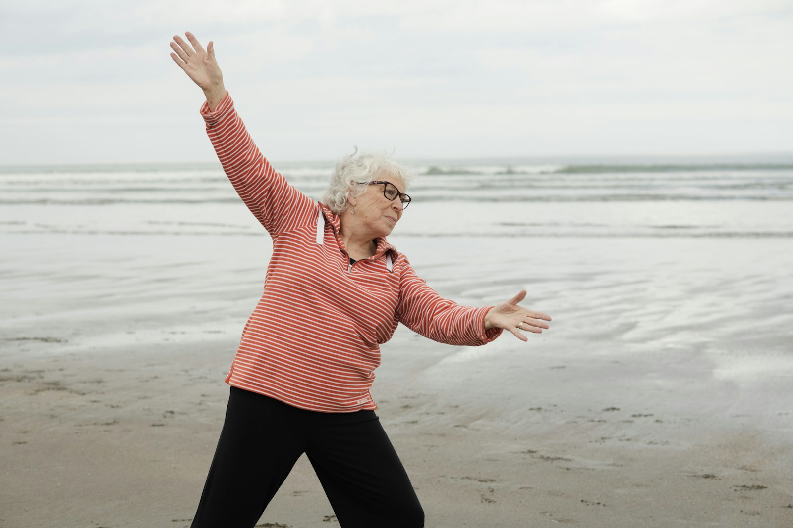 Older woman stretching on the beach
